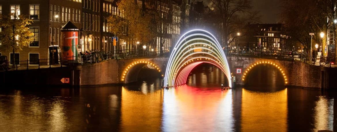Rainbow light arches over a canal bridge